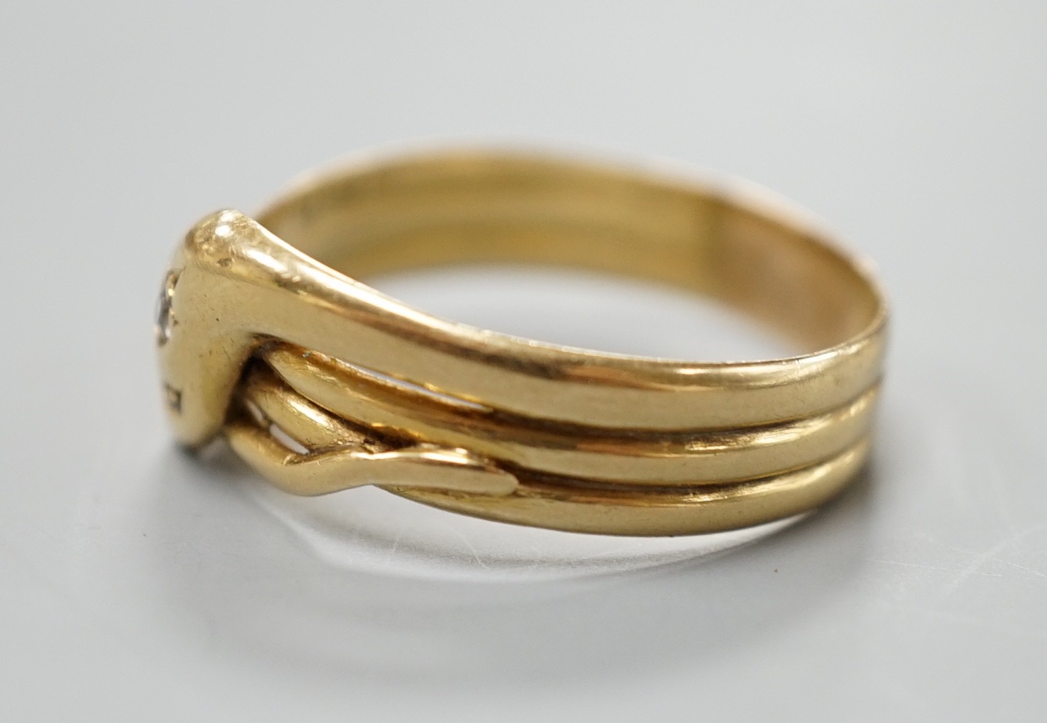 An Edwardian 18ct gold and diamond chip set serpent ring, size X/Y, gross 5.6 grams.